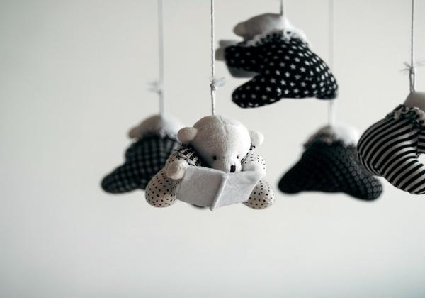 stuffed elephants dressed in black and white hang from a mobile