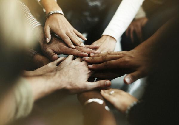 multi-racial hands touch in a circle