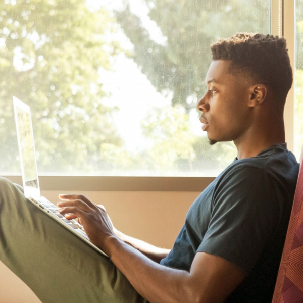 young man seated with laptop